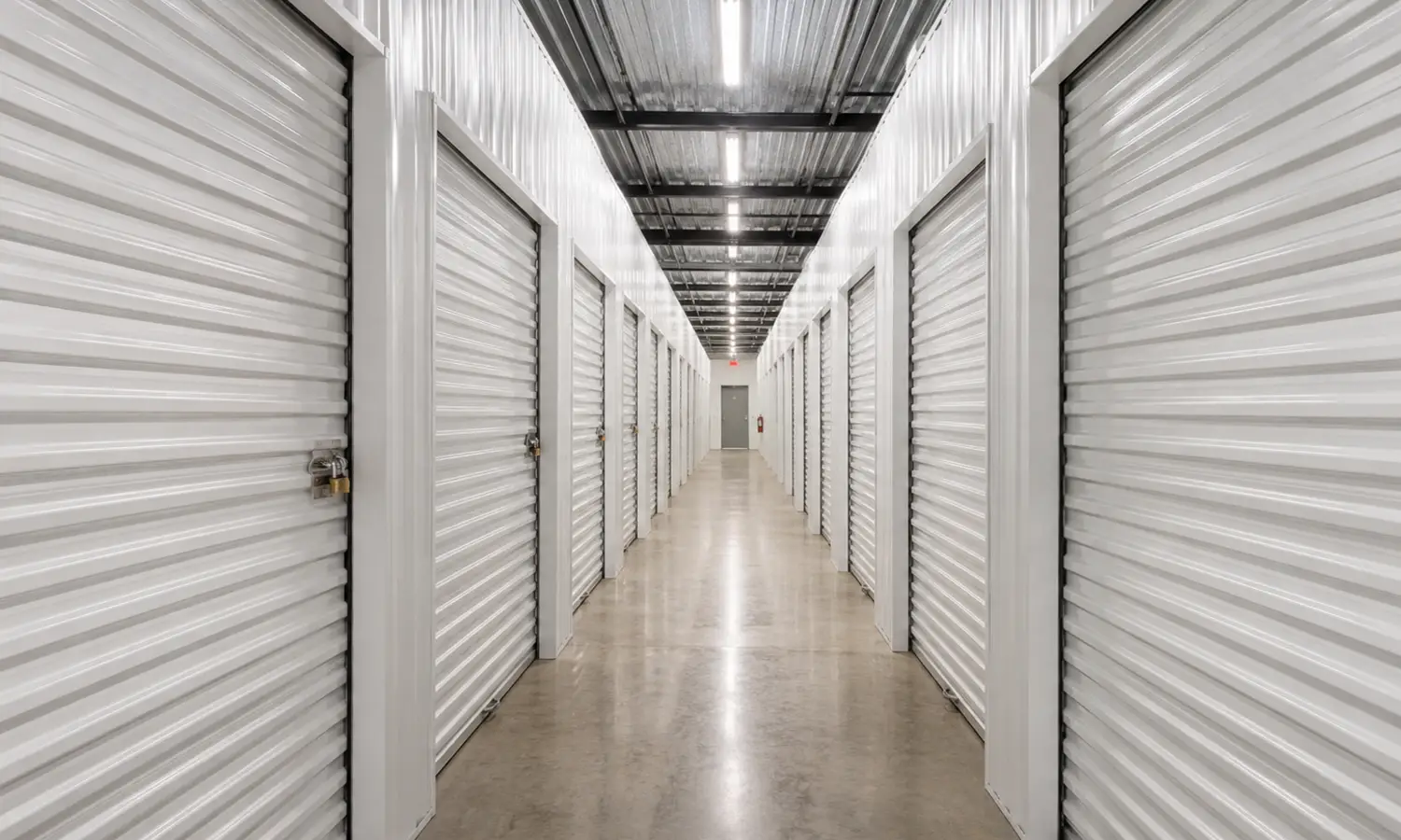 Pasillo interior de un centro de trasteros con unidades individuales y puertas metálicas